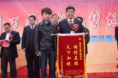 已榮升長沙市某美容店技術總監的湖南萬通畢業學子胡先生為母校送錦旗