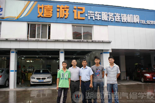 嘻游記汽車服務連鎖機構門口,陸金勇等幾位畢業學子與公司老總和陸主管合影