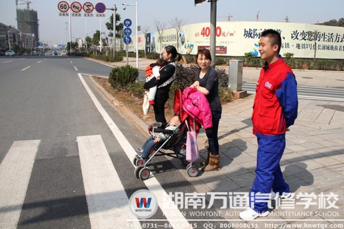 瞧，這兩位帶著寶寶的媽媽在萬通學子的提醒下停在人行道路旁
