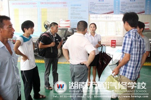 在高級轎車實訓(xùn)中心，咨詢老師給學(xué)生及其家人講述要學(xué)習(xí)的課程